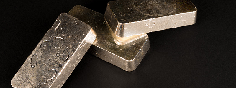 Close-up of silver bullion bars stacked on a reflective surface